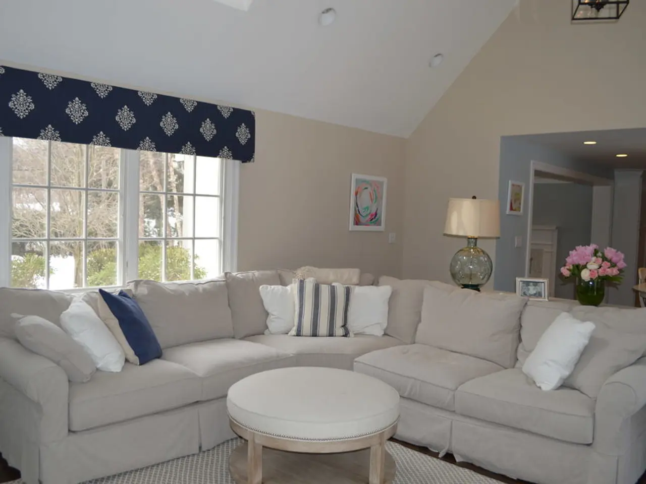 In this picture there is a couch with some pillows and there is a table and chairs here, there is a...